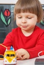 Happy preschooler playing with sunglasses and toy car. Child development