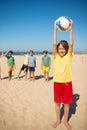 Happy preteen boy posing with ball over head Royalty Free Stock Photo