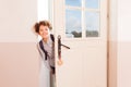 Happy schoolboy looking through the doorway Royalty Free Stock Photo