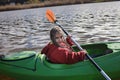 Happy preteen girl kayaking on river, paddle in the hand, summer camp activity, extreme sport Royalty Free Stock Photo