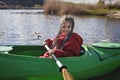 Happy preteen girl kayaking on river, paddle in the hand, summer camp activity, extreme sport Royalty Free Stock Photo