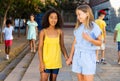 Happy preteen girls walking along city street