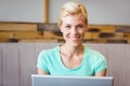 Happy pretty blonde using computer and looking at camera Royalty Free Stock Photo