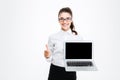 Happy pretty businesswoman with blank screen laptop showing thumbs up Royalty Free Stock Photo