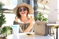 Happy pretty girl eating an ice cream while siting at summer street cafe Royalty Free Stock Photo