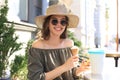 Happy pretty girl eating an ice cream while siting at summer street cafe Royalty Free Stock Photo