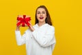 Happy pretty girl with long chestnut hair holding gift box wondering whats inside as celebrating birthday, receive b-day presents Royalty Free Stock Photo