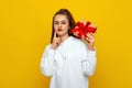 Happy pretty girl with long chestnut hair holding gift box wondering whats inside as celebrating birthday, receive b-day presents Royalty Free Stock Photo