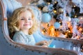 Happy pretty girl sitting in chair and holding christmas present Royalty Free Stock Photo