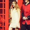 Happy pretty girl talking on phone in red telephone box Royalty Free Stock Photo