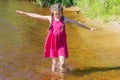 Happy pretty girl walks barefoot on the water on a warm summer sunny day. Royalty Free Stock Photo