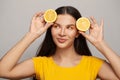 Happy pretty healthy woman with clear skin and straight hair holding lemon fruits on white background. Royalty Free Stock Photo