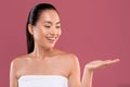 Happy pretty korean woman holding something invisible on her palm Royalty Free Stock Photo