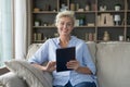 Happy pretty mature retired woman holding digital tablet computer Royalty Free Stock Photo