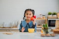 Happy pretty small child girl holding red tomato a vegetable for healthy in the kitchen room at home Royalty Free Stock Photo