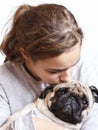 Happy pretty smiling teenager girl hugging pug dog with love Royalty Free Stock Photo