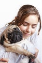 Happy pretty smiling teenager girl hugging pug dog with love Royalty Free Stock Photo