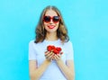 Happy pretty smiling woman with many strawberry over blue