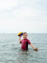 Happy teen girl in neoprene swimingsuit  playing with ball and running in sea Royalty Free Stock Photo