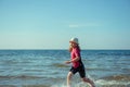 Happy pretty teen girl in neoprene swimingsuit  running in Baltic sea Royalty Free Stock Photo