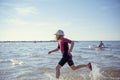 Happy pretty teen girl in neoprene swimingsuit  running in Baltic sea Royalty Free Stock Photo