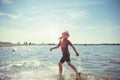 Happy pretty teen girl in neoprene swimingsuit  running in Baltic sea Royalty Free Stock Photo