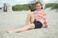 Happy pretty teen girl sitting on sunny white beach at summer holidays Royalty Free Stock Photo