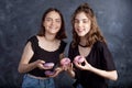 Happy pretty teenage girls with donuts having fun. Portrait of joyful girls with donuts on black background. Good mood, diet Royalty Free Stock Photo
