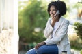Happy pretty young black woman talking on phone at park Royalty Free Stock Photo