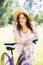 Happy pretty young girl bicycling on summer park. Happy relax time in city. Beautiful woman, sunny day