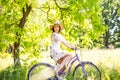 Happy pretty young girl bicycling on summer park. Happy relax time in city. Beautiful woman, sunny day