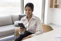 Happy pretty young Indian professional woman typing on mobile phone Royalty Free Stock Photo