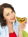 Happy Pretty Young Woman Eating a Slice of Freshly Baked Vegetarian Pizza Royalty Free Stock Photo