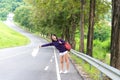 Happy pretty young woman with hand up calling passing car Royalty Free Stock Photo