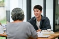 A happy Asian male architect is consulting on building plans and designs with a client Royalty Free Stock Photo