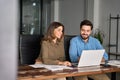 Happy professional business people working in office with laptop and talking. Royalty Free Stock Photo