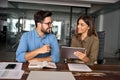 Happy professional business people working in office with tablet and talking. Royalty Free Stock Photo