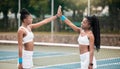 Happy professional tennis players high five after a match on the court. Young girls support each other after tennis Royalty Free Stock Photo