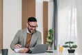 Happy professional writing business ideas while working on laptop at office desk Royalty Free Stock Photo