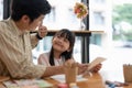 Happy proud asian father and daughter having fun together, drawing and painting watercolor. Royalty Free Stock Photo