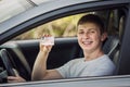 Happy and proud guy showing his driver license out of the car window Royalty Free Stock Photo