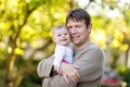 Happy proud young father having fun with newborn baby daughter, family portrait togehter. Dad with baby girl outdoors Royalty Free Stock Photo