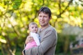 Happy proud young father having fun with newborn baby daughter, family portrait togehter. Dad with baby girl outdoors Royalty Free Stock Photo