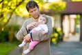 Happy proud young father having fun with newborn baby daughter, family portrait togehter. Dad with baby girl outdoors Royalty Free Stock Photo