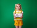 Happy pupil with backpack isolated on green with schoolbooks Royalty Free Stock Photo