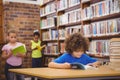 Happy pupil reading a library book