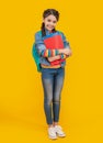 Happy pupil yellow background. Teenage pupil holding books. Pupil back to school