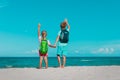 happy ravel on beach, boy and girls with backpack at sea Royalty Free Stock Photo