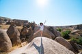 Happy raveler girl on top of the mountain. Devrent Valley / Imaginary Valley full of unique rose rock formations in Cappadocia,