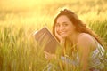 Happy reader holding book looks at camera